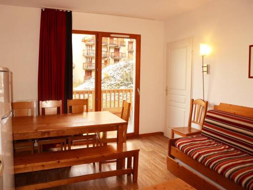 une salle à manger avec une table et un canapé dans l'établissement Grand appartement pour 8 avec piscine intérieure chauffée, jacuzzi et grande terrasse exposée sud - FR-1-322-378, aux Orres