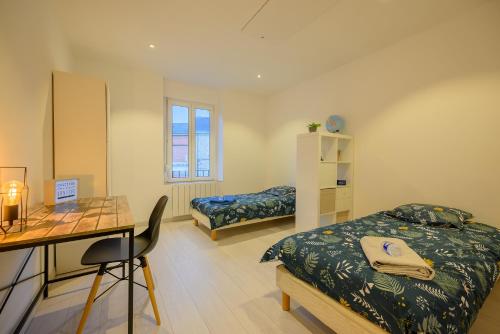 Zimmer mit 2 Betten, einem Schreibtisch und einem Tisch in der Unterkunft Villa Ma Bohème - 6 pers. in Charleville-Mézières