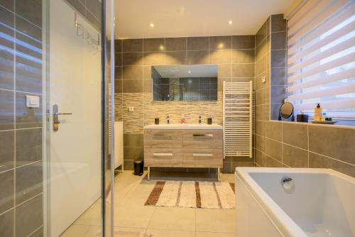 a bathroom with a tub and a sink and a mirror at Villa Ma Bohème - 6 pers. in Charleville-Mézières