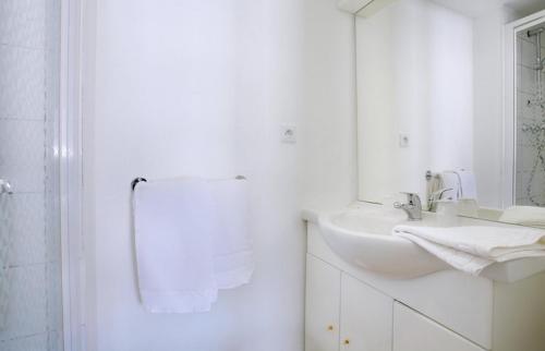 uma casa de banho branca com um lavatório e um espelho em Couett' Hotel Rumilly em Rumilly