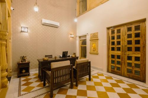 a home office with a desk and two chairs at Dev Garh in Jaisalmer