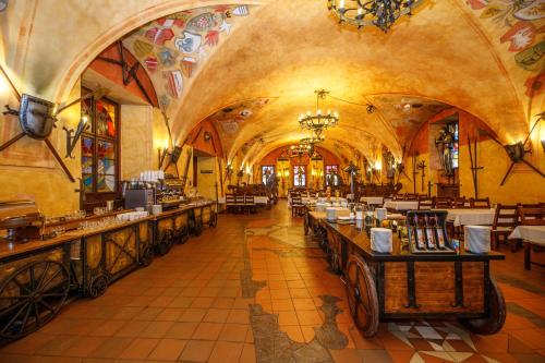 a restaurant with long tables in a large building at Pytloun Old Armoury Hotel Prague, Stará Zbrojnice in Prague