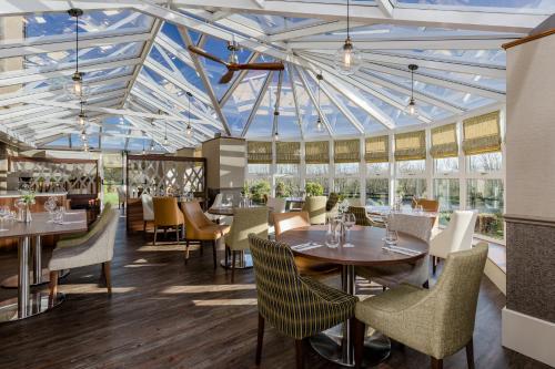 comedor con mesas y sillas y techo de cristal en The Melbreak Hotel, en Great Clifton