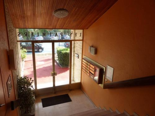 une entrée d'un bâtiment avec une grande porte vitrée dans l'établissement Bel appartement climatisé 2 pièces au centre avec terrasse - FR-1-308-47, au Lavandou