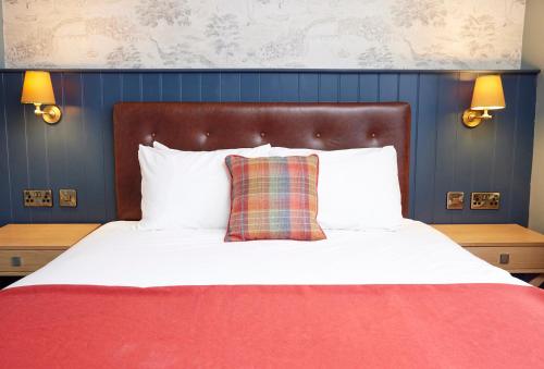 una camera da letto con un grande letto con una coperta rossa di Castle Hotel by Chef & Brewer Collection a Leicester
