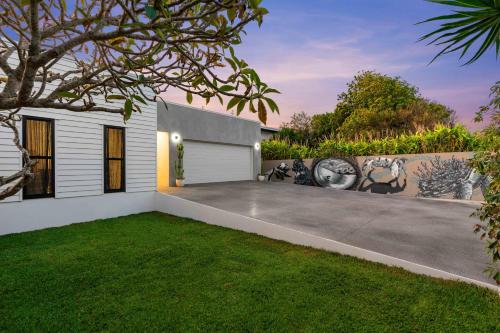 a backyard of a house with a driveway at Luxury Modern 4 BR Pet Friendly Family Beach Home in Yaroomba