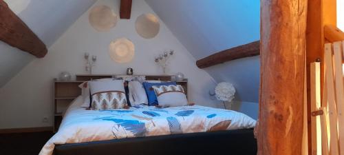 a bedroom with a bed with pillows on it at Gite De La Baguelande in Les Andelys