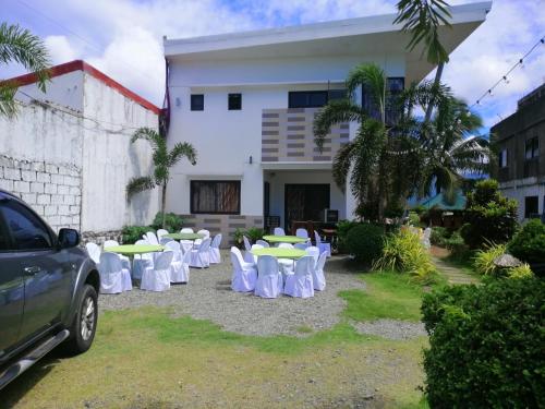 a group of tables and chairs in front of a building at Casa Herminia Baler in Baler