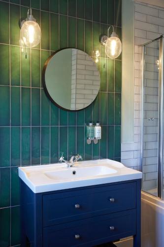 a bathroom with a blue sink and a mirror at Castle Hotel by Chef & Brewer Collection in Leicester