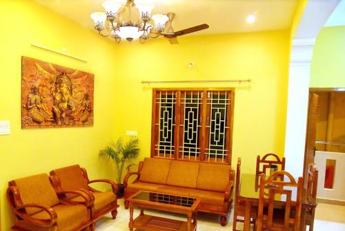 a living room with a couch and chairs and a painting at Sri Apt Homestay A1 Family-Friendly 2BHK with Kitchen in Puducherry