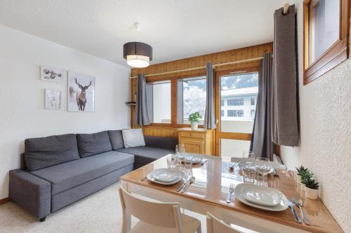 un salon avec un canapé gris et une table dans l'établissement Les Jardins du Mont-Blanc - Happy Rentals, à Chamonix-Mont-Blanc