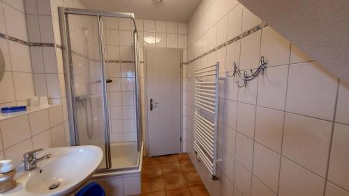 a bathroom with a sink and a glass shower at Ferienwohnung im Uhlenhuus in Wiek auf Rügen 