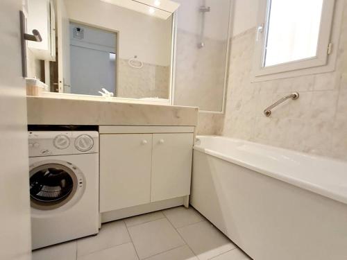 une salle de bain blanche avec une machine à laver et un lavabo dans l'établissement T2 climatisé avec coin nuit, parking, piscine et tennis - 200m plages et commerces - FR-1-316-154, à Six-Fours-les-Plages