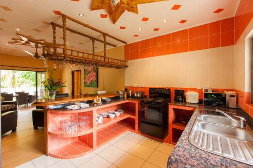 a kitchen with orange tile walls and a counter top at Casa De Leela Self Catering Guest House in La Digue