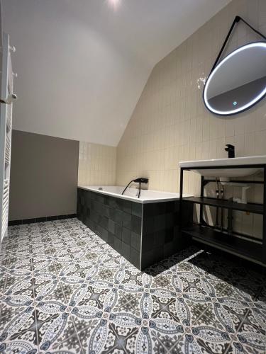 La salle de bains est pourvue d'une baignoire et de carrelage. dans l'établissement Maison en pleine forêt à 10min de Reims, à Saint-Brice-Courcelles