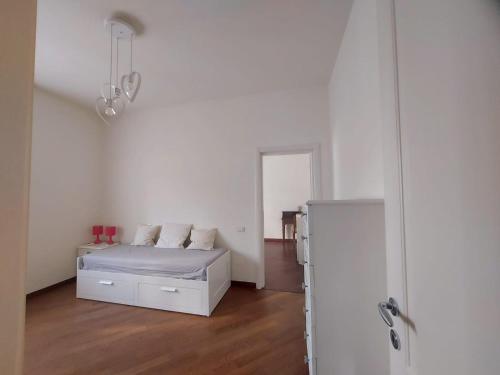 a white bedroom with a bed and a refrigerator at Appartamento 3 Cuori in Terni