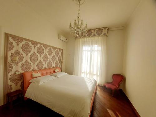 a bedroom with a white bed and a chandelier at Appartamento 3 Cuori in Terni