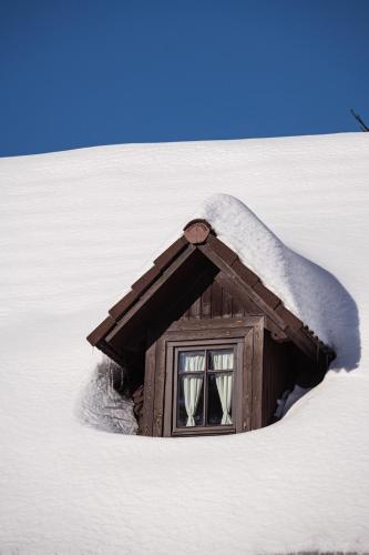 a small house with snow on the side of a hill at Penzion Statek u Rajtrů in Bedřichov