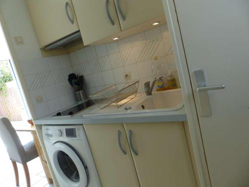 une cuisine avec un évier et une machine à laver dans l'établissement Mazet Climatisé 3P avec Terrasse et Piscine - Le Lavandou - FR-1-308-78, au Lavandou