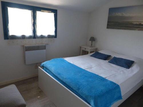 - une chambre avec un lit doté de draps bleus et 2 fenêtres dans l'établissement Mazet Climatisé 3P avec Terrasse et Piscine - Le Lavandou - FR-1-308-78, au Lavandou