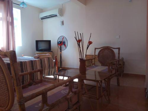 a living room with a table and chairs and a television at Chetty Tourist Residence in Pereybere