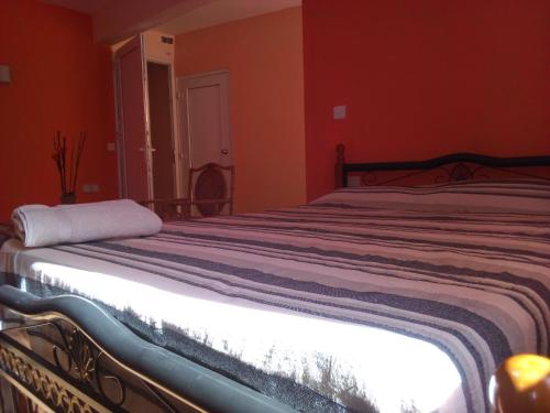 a bedroom with a large bed with orange walls at Chetty Tourist Residence in Pereybere