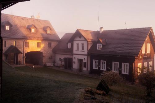a group of houses with the sun shining on them at Penzion Statek u Rajtrů in Bedřichov