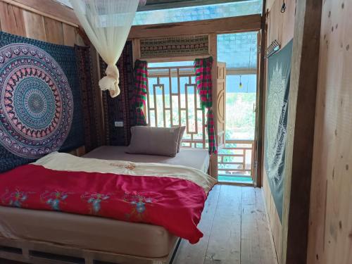 a bedroom with a bed with a red blanket at MyMy eco Homestay in Làng Cac