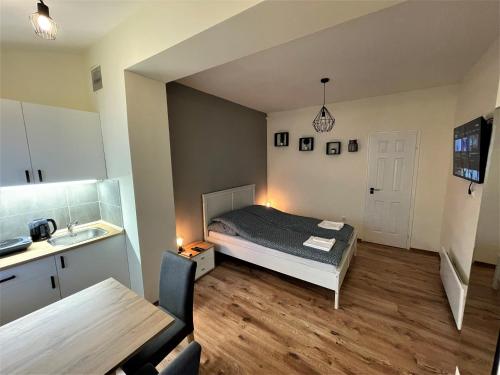 - une petite chambre avec un lit et une table dans l'établissement Hanna Apartman, à Debrecen