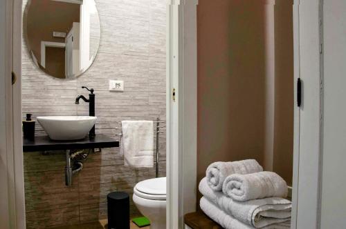 ein Badezimmer mit einem Waschbecken, einem WC und einem Spiegel in der Unterkunft B&B Benincasa in Palermo