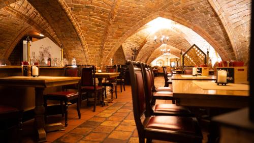 a restaurant with tables and chairs in a room at Hotel Am Hopfenmarkt in Rostock