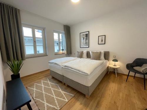 a bedroom with a large bed and a chair at Gmund Seeliebe Premiumsuite in Gmund am Tegernsee