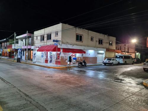 una calle vacía por la noche con un paraguas rojo en CASA NURIA, en Playa del Carmen