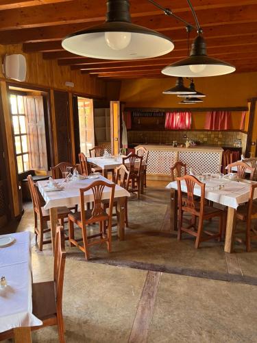 una sala da pranzo con tavoli bianchi e sedie in legno di Hotel Rural Rosario Martin a Puerto del Rosario
