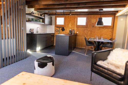 a kitchen and a living room with a table and chairs at Ferienwohnung im Chalet am Bach in Schwarzsee
