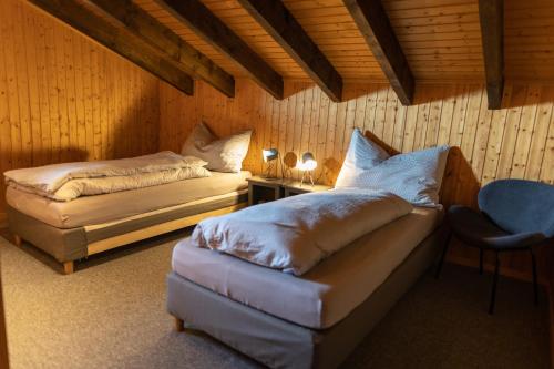 a bedroom with two beds and a table and a chair at Ferienwohnung im Chalet am Bach in Schwarzsee