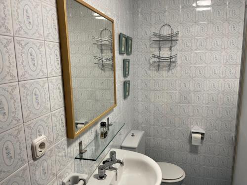 La salle de bains est pourvue d'un lavabo, d'un miroir et de toilettes. dans l'établissement Apartamento Ravel Playa Málaga, à Malaga