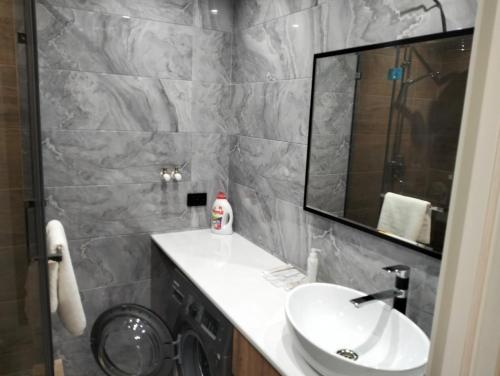 La salle de bains est pourvue d'un lavabo et d'un miroir. dans l'établissement 1-ком VIP квартира, à Kostanay
