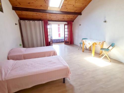 Cette chambre comprend 3 lits, une table et des chaises. dans l'établissement Villa T3 avec Piscine, Jardin et Parking - Proche Plages et Commerces - FR-1-316-219, à Le Brusc