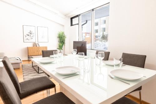 comedor con mesa blanca y sillas en 2ndhomes Unique & Spacious 2-Storey Apartment with Sauna, en Helsinki