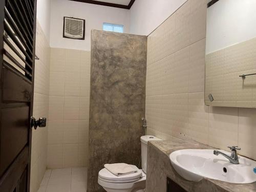 ein Bad mit einem Waschbecken, einem WC und einer Dusche in der Unterkunft Jasmine Place House in Luang Prabang