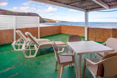 a patio with tables and chairs and the ocean at Las Sales Duplex in Moya