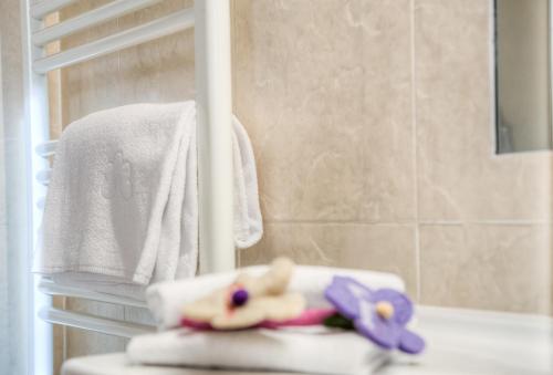 a bathroom with two dolls sitting on a towel at Eden Apartments in Siusi