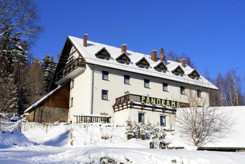 a large white building in the snow at Villa Panorama in Stronie Śląskie