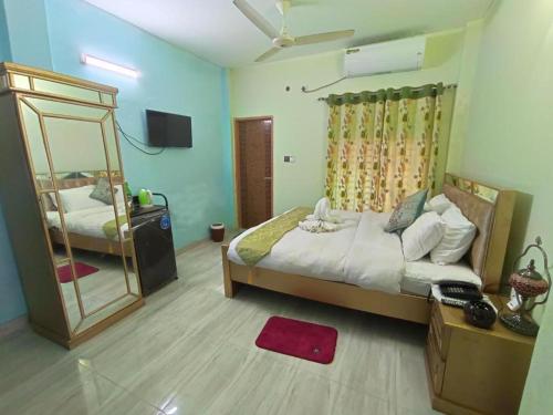 Banorupa Kuakata hotel في كواكاتا: غرفة نوم بسرير كبير ومرآة