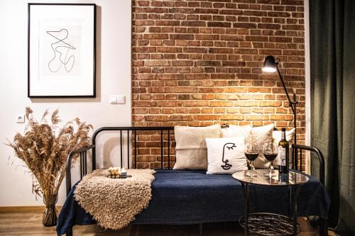 a bedroom with a bed with a brick wall at Wine Apartments in Kraków