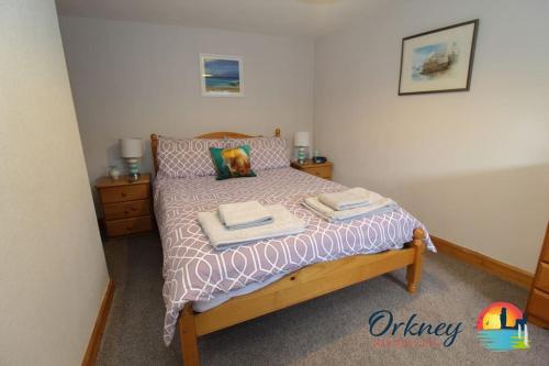 een slaapkamer met een bed met twee handdoeken erop bij Khyber Pass Cottage, Stromness - OR00332F in Stromness