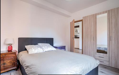 a bedroom with a white bed and a wooden cabinet at Proche centre de Strasbourg et Parlement Européen in Schiltigheim