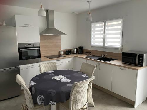 a kitchen with a table and chairs in a kitchen at Repos paisible in Talmont