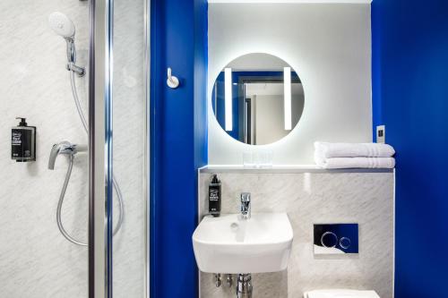 La salle de bains est pourvue d'un lavabo et d'un miroir. dans l'établissement ibis budget Manchester Airport, à Hale